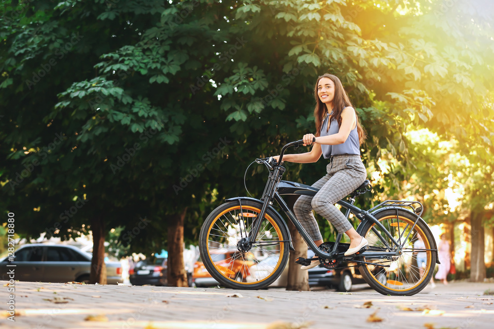Young woman riding bicycle outdoors