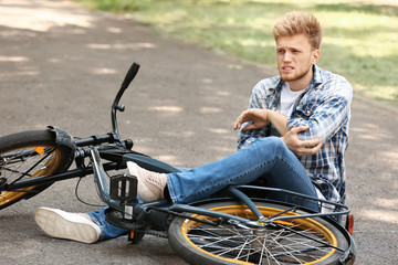 Young man fallen off his bicycle outdoors