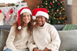 © Pixel-Shot - Portrait of African-American woman and her daughter in Santa hats at home