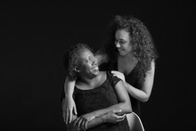 Black And White Portrait Of African-American Woman With Her Daughter On Dark Background