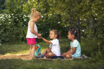 Happy children girls friends playing together outdoors on grass lawn in park as countryside lifestyle symbolizing friendship and happy childhood