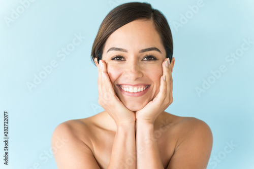 Fotomural Female With Hands On Face Against Plain Background