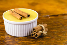 Brazilian Sweet Cream-like Dessert Cured Corn Mousse With Cinnamon On A Rustic Wooden Background. Typical Brazilian Cuisine Sweet In Traditional Parties, On A Wooden Background With Copy Space.