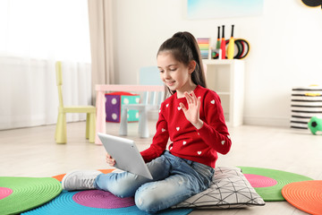 Poster - Little girl using video chat on tablet in playroom