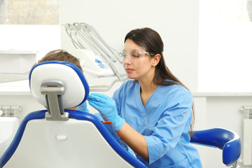 Wall Mural - Professional dentist working with little boy in clinic