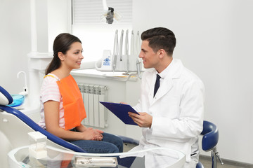 Canvas Print - Professional dentist working with patient in clinic