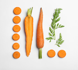 Cut carrots and leaves isolated on white, top view