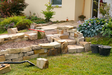 stone steps and dry stone wall under construction - landscaping works with natural stones