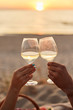 Couple clinking glasses of champagne at sunset