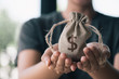© Looker_Studio - Women hand hold a money bag, a loan or saving money for future investment concept.