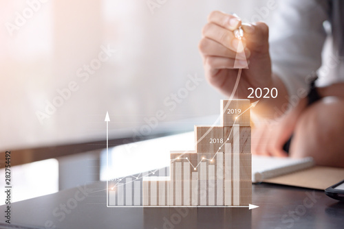 Fotomural woman use pen plans to increase business growth and an increase in the indicators of positive growth in 2020 on virtual screen