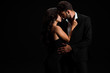 © LIGHTFIELD STUDIOS - attractive girl touching suit of passionate bearded man isolated on black