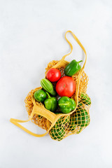 Products and Fresh vegetables in a mesh bag on a white background..Zero waste shopping concept. Recycling. Awareness consumption. Sustainable lifestyle.