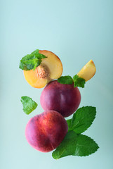 Tasty, ripe, aromatic peaches with fresh mint on a colored background