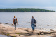 © Tatyana_Andreyeva - Middle aged man and young lady walking on northern lake shore in summer day. Tourists against picturesque landscape. Travelling and discovering distant places of Earth. Onega lake, Karelia, Russia