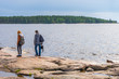 © Tatyana_Andreyeva - Middle aged man and young lady walking on northern lake shore in summer day. Tourists against picturesque landscape. Travelling and discovering distant places of Earth. Onega lake, Karelia, Russia