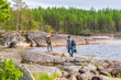 © Tatyana_Andreyeva - Middle aged man and young lady walking on northern lake shore in summer day. Tourists against picturesque landscape. Travelling and discovering distant places of Earth. Onega lake, Karelia, Russia