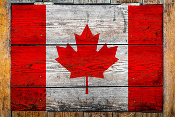 Wall Mural - National flag of Canada on a wooden wall background.The concept of national pride and symbol of the country.Flag painted on a wooden fence with metal nails.