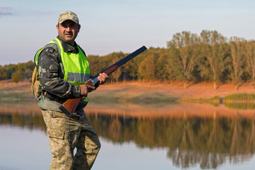 Hunter with a german drathaar and spaniel, pigeon hunting with dogs in reflective vests	