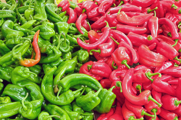 Green and red jalapeno peppers for sale at a market