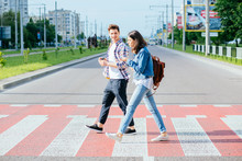 A Picture Of A Happy Young Family On A Walk On A Day Off. A Happy Family Crosses The Road At A Pedestrian Crossing
