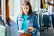 © Iryna - Two cheerful pretty young women are sitting in front of each other in a bus or tram and looking at the books, reading, talking smiling while waiting for a bus to take them to their destination.