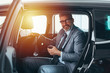 © cherryandbees - senior bearded gray haired businessman sitting backseat in car