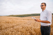 © Serhii - Agriculture, farmer or agronomist inspect quality of wheat in field ready to harvest