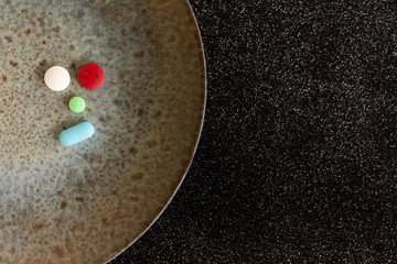 Wall Mural - Colored pills or medications on a plate. Health concept. Copy space Legal drugs of the pharmaceutical industry.