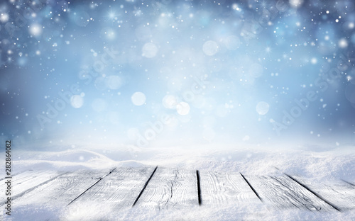 Obrazy zima   piekna-zima-sniezna-niewyrazne-niewyrazne-niebieskie-tlo-i-pusta-drewniana-podloga-platki