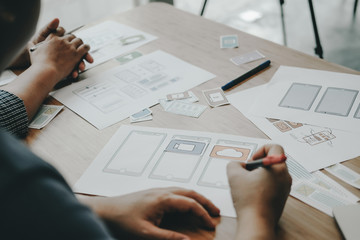user experience UX designer designing web on smart phone layout. UI developer planning working on mobile application prototype