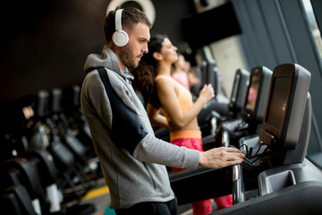 Young people using threadmill in modern gym