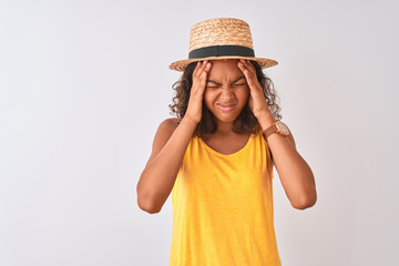 Wall Mural - Young brazilian woman wearing yellow t-shirt and summer hat over isolated white background suffering from headache desperate and stressed because pain and migraine. Hands on head.