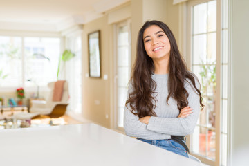 Young beautiful woman at home happy face smiling with crossed arms looking at the camera. Positive person.