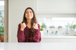 © Krakenimages.com - Young beautiful woman at home success sign doing positive gesture with hand, thumbs up smiling and happy. Looking at the camera with cheerful expression, winner gesture.