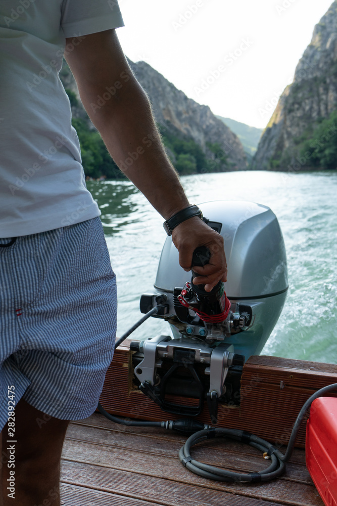 Fisherman holding small motor to drive the boat. A pilot control the ...