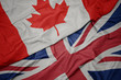 waving colorful flag of great britain and national flag of canada.