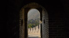 SLOW MOTION, CLOSE UP: Dark Corridor And Doorway Offers A Beautiful View Of The Great Wall Climbing The Forest Covered Mountain In The Idyllic Chinese Countryside. Walking Towards An Arched Portal.