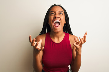 Sticker - African american woman wearing red casual t-shirt standing over isolated white background crazy and mad shouting and yelling with aggressive expression and arms raised. Frustration concept.