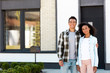 © LIGHTFIELD STUDIOS - african american husband and wife standing near new house and looking at camera