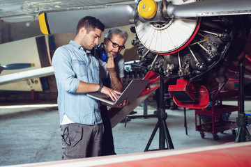 Engineer looking at laptop for maintenance an airplane