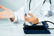 © Sebastian - A doctor wearing a white coat talks to a patient. Medical and pharmaceutical concept. The doctor provides information about the patient's health, treatment of diseases, health problems.