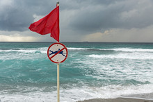 Red Warning Flag On Sea Beach
