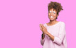 © Krakenimages.com - Beautiful young african american woman wearing glasses over isolated background Clapping and applauding happy and joyful, smiling proud hands together