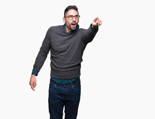 Young handsome man wearing glasses over isolated background Pointing with finger surprised ahead, open mouth amazed expression, something in front