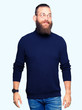 © Krakenimages.com - Young blond man wearing glasses and turtleneck sweater smiling looking side and staring away thinking.