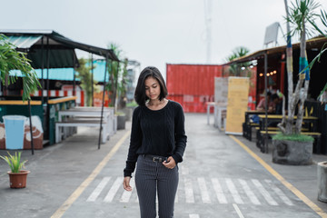 Wall Mural - Pose of asian young woman wearing black casual clothes walking on the way