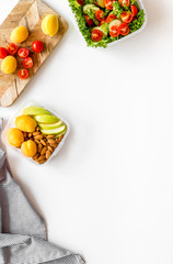 to-go box with salad and fruit for lunch on white background top view copyspace