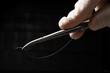 © Julio Ricco - Doctor holding needle holder for surgery with blue nylon surgical thread.