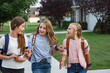 © Brocreative - Group of young female friends and students talking together as they walk home school for the day